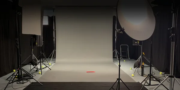Studio mit hellem Hintergrund, Stativen und Studioleuchten